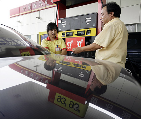 A taxi driver waits to fill up a car at a PetroChina gas station in Beijing.