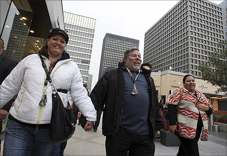 Apple co-founder Steve Wozniak (C) and his wife Janet walk hand-in-hand to the store entrance after waiting in line overnight with customers to purchase the new iPad at the Apple Store in Century City Westfield Shopping Mall in Los Angeles, California.
