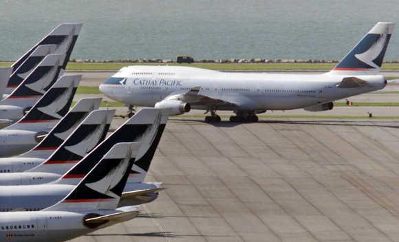 A Cathay Pacific Airways Boeing 747 passenger plane taxis past a column of the airlines