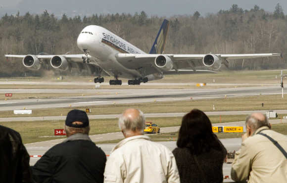 People watch an Airbus A380 jet of Singapore Airlines taking off from the airport in Zurich.
