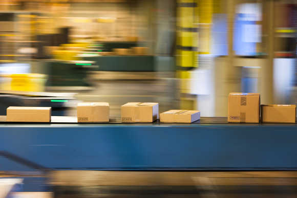 Parcels travel on a conveyer belt before being sorted for delivery in Daillens near Lausanne.