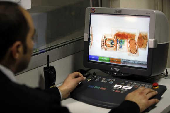 A security official looks at a screen displaying X-ray screened parcels in Turkish Post's postal logistic centre at the Ataturk International airport.