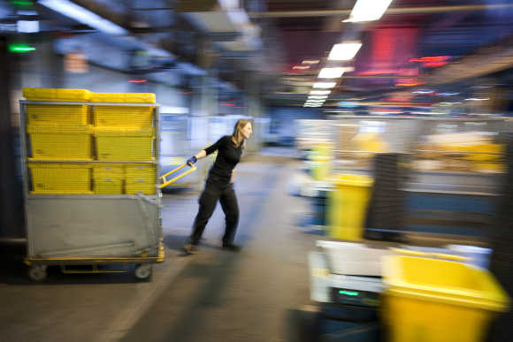 A Swiss post employee pulls a trolley loaded with parcels in Daillens near Lausanne.