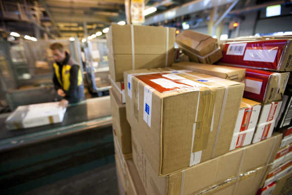 A Swiss post employee lines up parcels on a conveyer belt in Daillens near Lausanne.