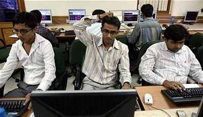 Brokers trade on their computer terminals at a brokerage firm in Mumbai.
