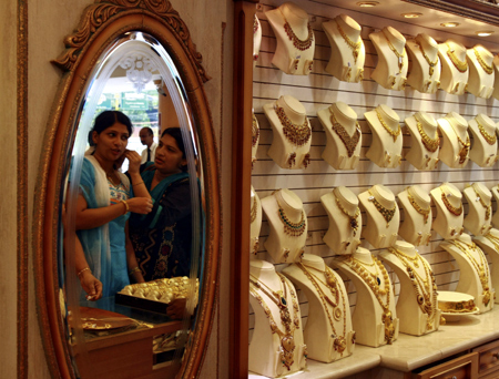 A woman tries a gold earring inside a gold jewellery showroom in Kochi.
