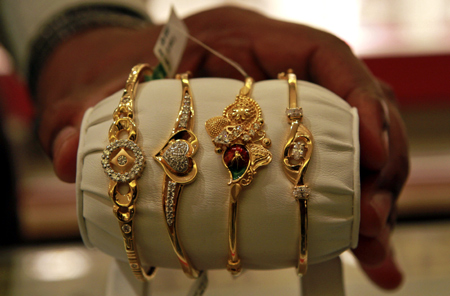 A salesman displays gold bangles to a customer at a jewellery showroom in Chennai.