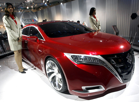 This file photo shows models standing next to Maruti-Suzuki's Kizashi, concept car.