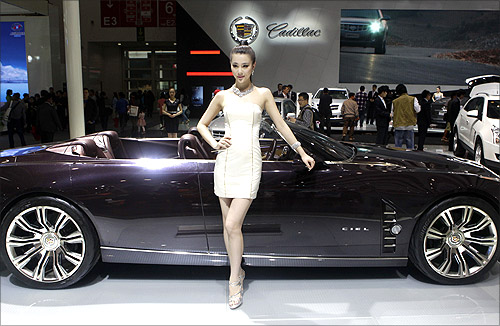 A model stands next to a Cadillac CIEL concept car at Auto China 2012 in Beijing.