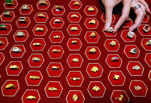 A shopkeeper poses with gold rings inside a jewellery shop in Taipei.