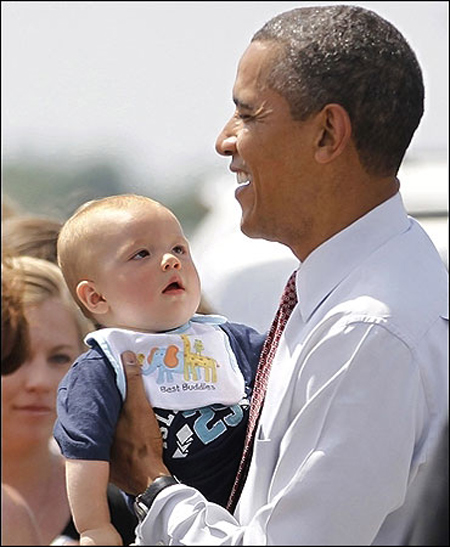 US President Barack Obama holds a baby during his visit to Fort Drum in New York.