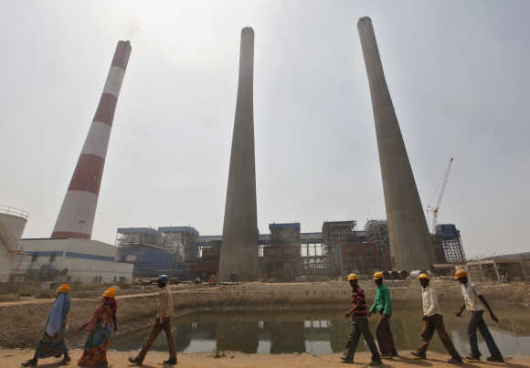 Workers walk inside the Jindal Power and Steel complex at Nisha village in Orissa.
