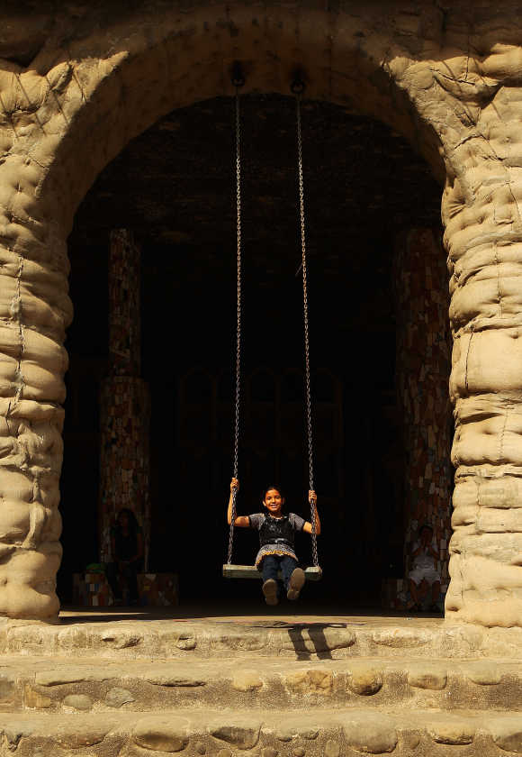 A young girl plays on the swings at the Rock Garden in Chandigarh.