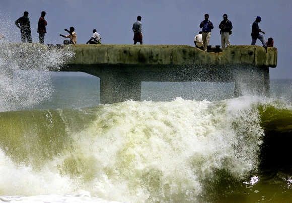 Indians enjoy the splash of huge sea waves from a bridge in Thiruvananthapuram..