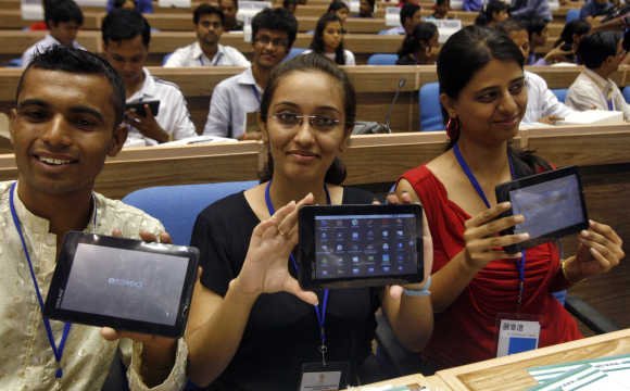 Students display Aakash at its launch ceremony in New Delhi.