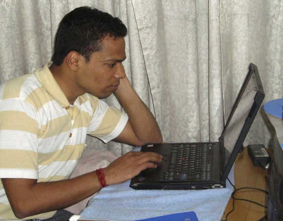 Abhishek Chaudhary, a B-School student, works on his laptop inside his house in New Delhi.