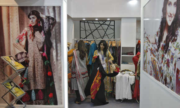 Exhibitors from Pakistan prepare their stall of clothing at the Lifestyle Pakistan Exhibition in New Delhi.
