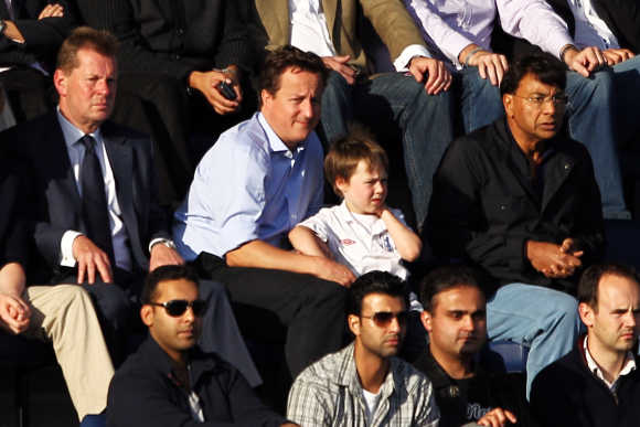 British Prime Minister David Cameron, his son Arthur and Lakshmi Mittal watch the Barclays Premier League match between Queens Park Rangers and Aston Villa at Loftus Road in London, England.