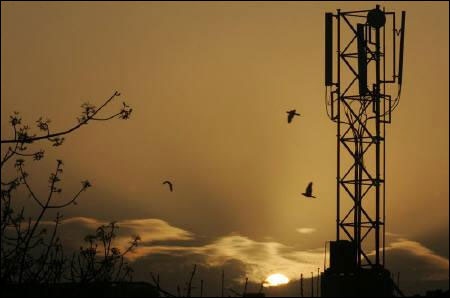 The sun rises behind a communications tower in New Delhi.