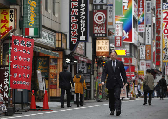 A man walks through a street in Tokyo's Shinjuku district.