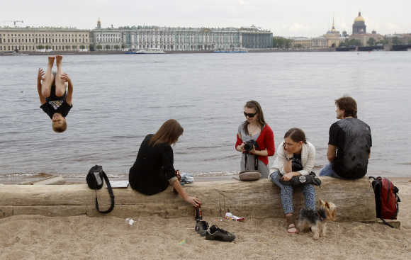 People enjoy a warm day on the banks of the Neva River in central St Petersburg.