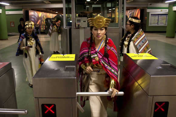 A dancer from a Peruvian folkloric group passes through a turnstile at a subway station in Santiago.