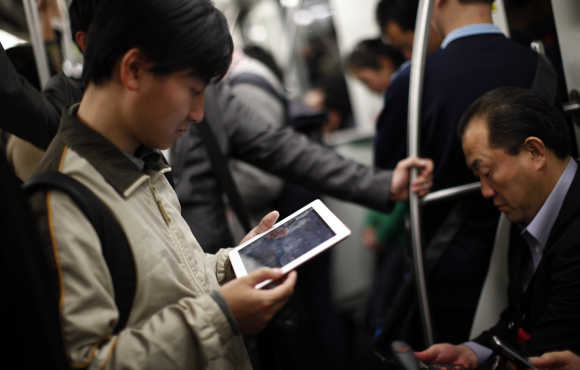 A man holds an Apple iPad as he travels on the subway in downtown Shanghai.