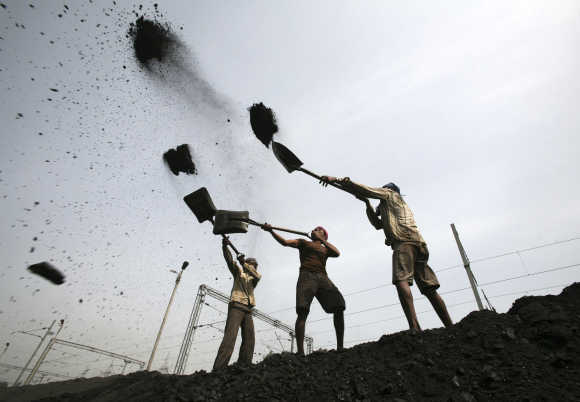 Labourers load coal on trucks at Bari Brahamina on the outskirts of Jammu.