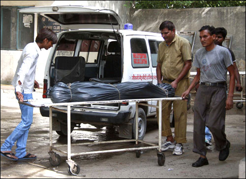 Hospital staff move the covered body of Awanish Kumar Dev, human resources manager at Maruti Suzuki.