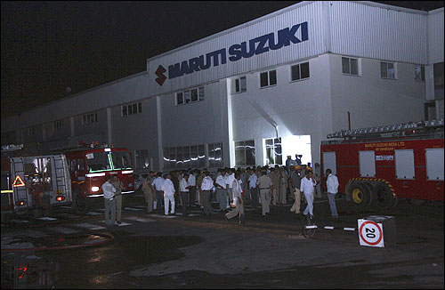 Police and firefighters are seen at the Maruti Suzuki's plant after the clash.