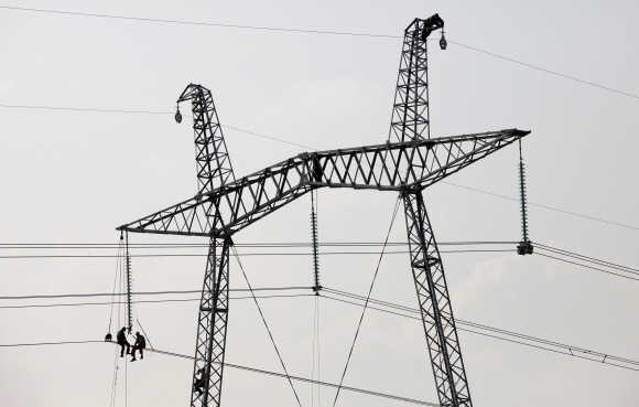 Mechanics work on an electricity pylon in the steppe area near the village of Solyonoozyornoye in Russia's Khakassia region.