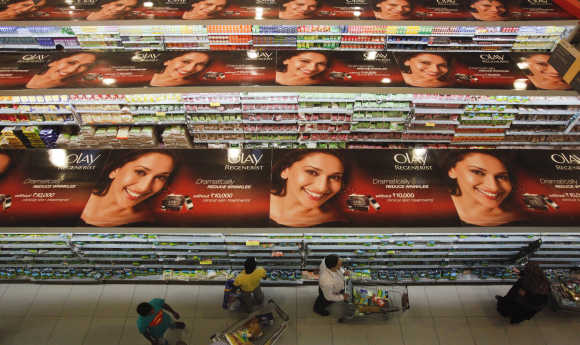 People push trolleys down the aisles as they shop at a department store in Mumbai.