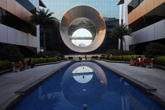 Employees walk in front of a building dubbed the 'washing machine', a well-known landmark built by Infosys at the Electronics City IT district in Bangalore.