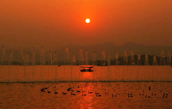 A fishing boat is seen at sunset on the West Lake in Hangzhou, capital city of east China's Zhejiang Province.