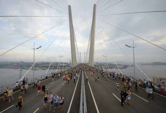 People walk on the bridge across the Golden Horn bay after its opening in Vladivostok, Russia.