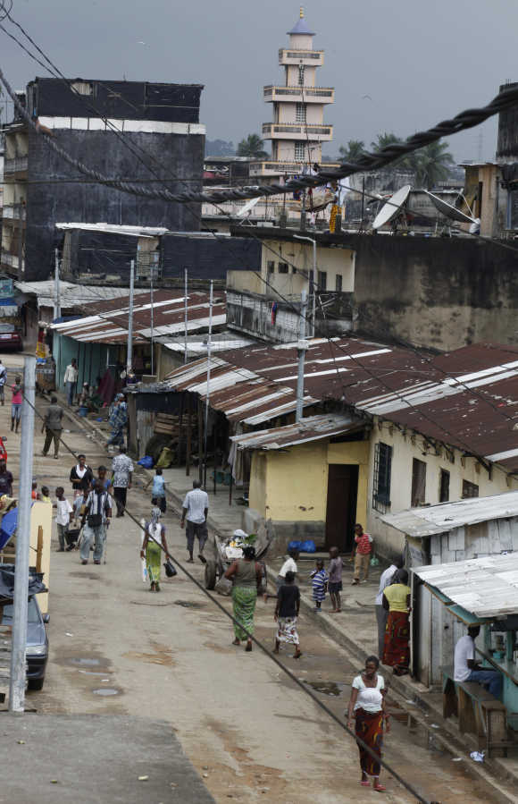 People walk down a street in Adjame, Abidjan, Ivory Coast.