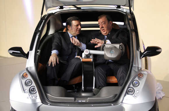 European Commission President Jose Manuel Barroso, left, and Jesus Echabe, right, President of Hiriko, inside the car at the EU headquarters in Brussels.