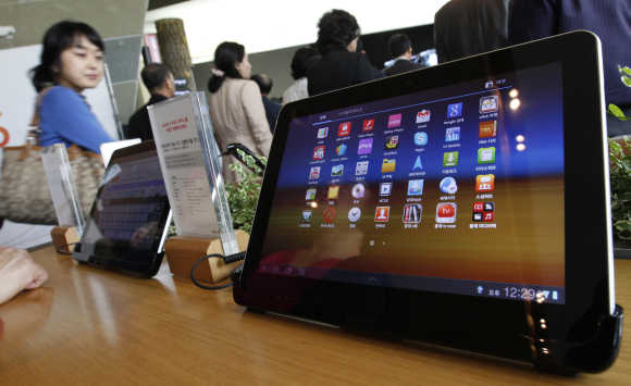 Visitors walk past Samsung Electronics' Galaxy Tab 10.1 tablets on display in Seoul.