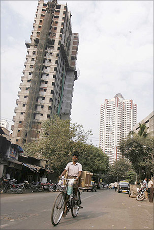 A man cycles past newly constructed buildings.