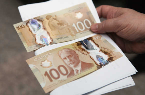 A man holds Canadian dollar notes in Toronto.