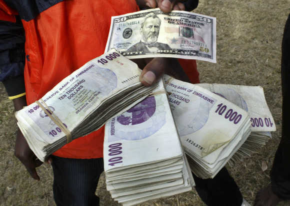A black market currency trader shows off US and Zimbabwean bank notes in the capital Harare.