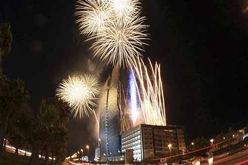 Fireworks explode above a giant video screen in Jeddah
