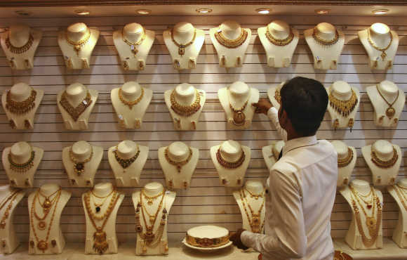 A salesman arranges a gold necklace inside a jewellery showroom in Kochi.
