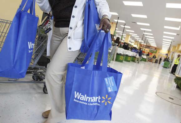 A shopper carries her purchases from Walmart Neighborhood Market in Chicago.