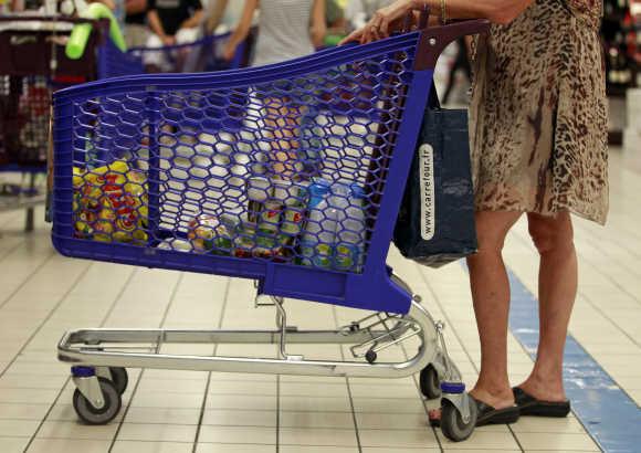 A customer pushes a shopping trolley down an aisle at Carrefour Planet supermarket in Nice, France.