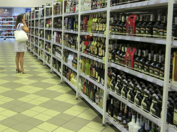 A shopper stands near bottles of alcohol at a supermarket in Kiev, Ukraine.