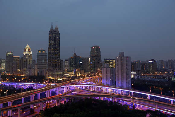 An aerial view shows vehicles travelling on intersections at night in downtown Shanghai.