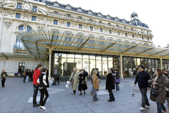 Toursits walk past the Orsay Museum in Paris.