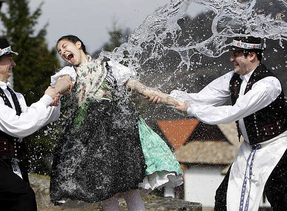 Boys hold onto a girl as they throw water at her as part of traditional Easter celebrations in Holloko near Budapest.