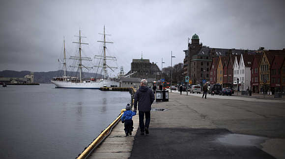 Man walks with a child near the marina in downtown Bergen.